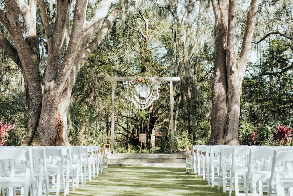 Outdoor Bohemian Wedding Ceremony with White Garden Chairs | Wooden Arch with Macrame Crochet Decor | Tampa Wedding Venue Paradise Springs