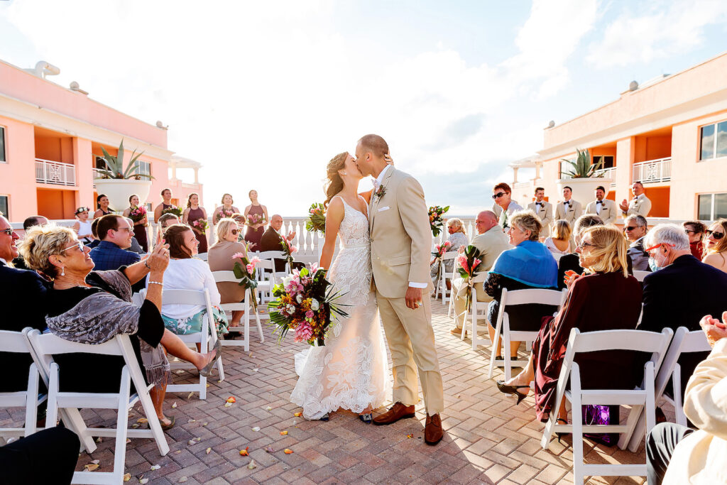 Florida Bride and Groom Kissing During Wedding Ceremony Exit on Rooftop Waterfront Wedding Venue Hyatt Regency Clearwater Beach | Tampa Bay Wedding Photographer Limelight Photography