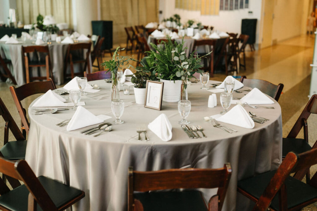 Elegant Modern Wedding Reception with Wooden Folding Chairs and Fern Greenery Centerpieces