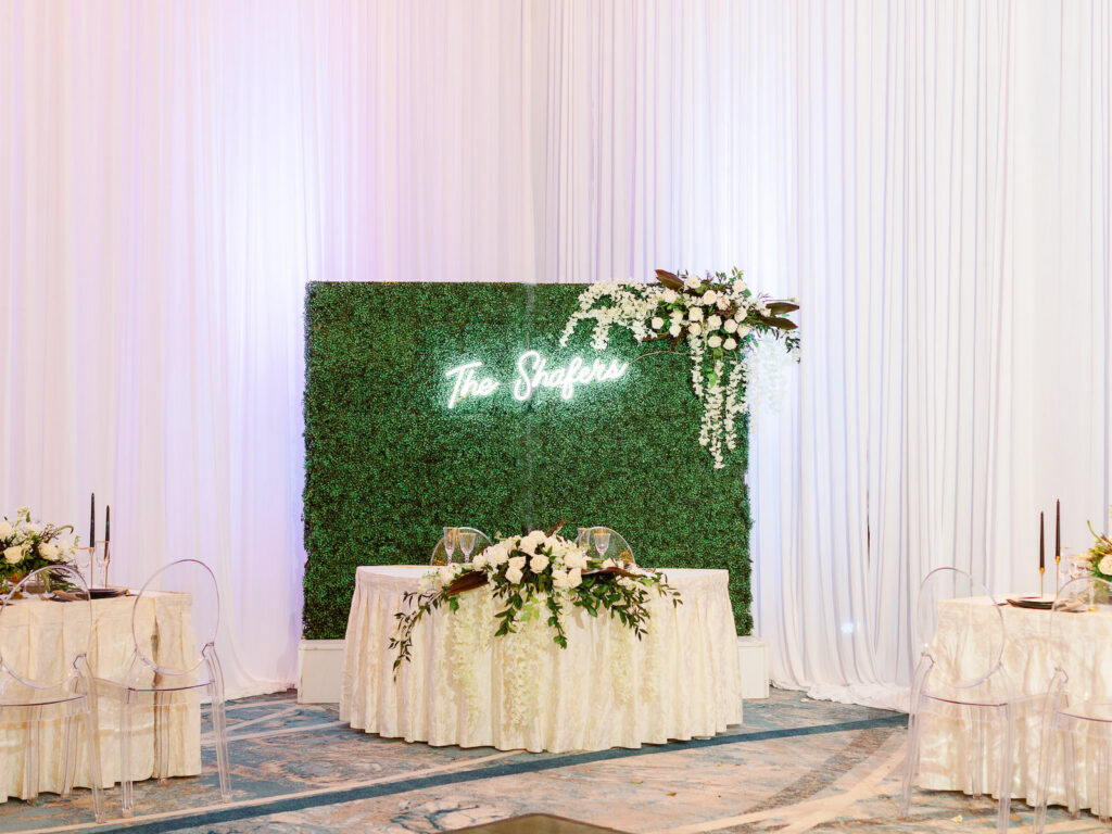 Wedding Reception Greenery Backdrop and Sweetheart Table with Neon Sign and White Floral Details | Hilton Downtown Tampa