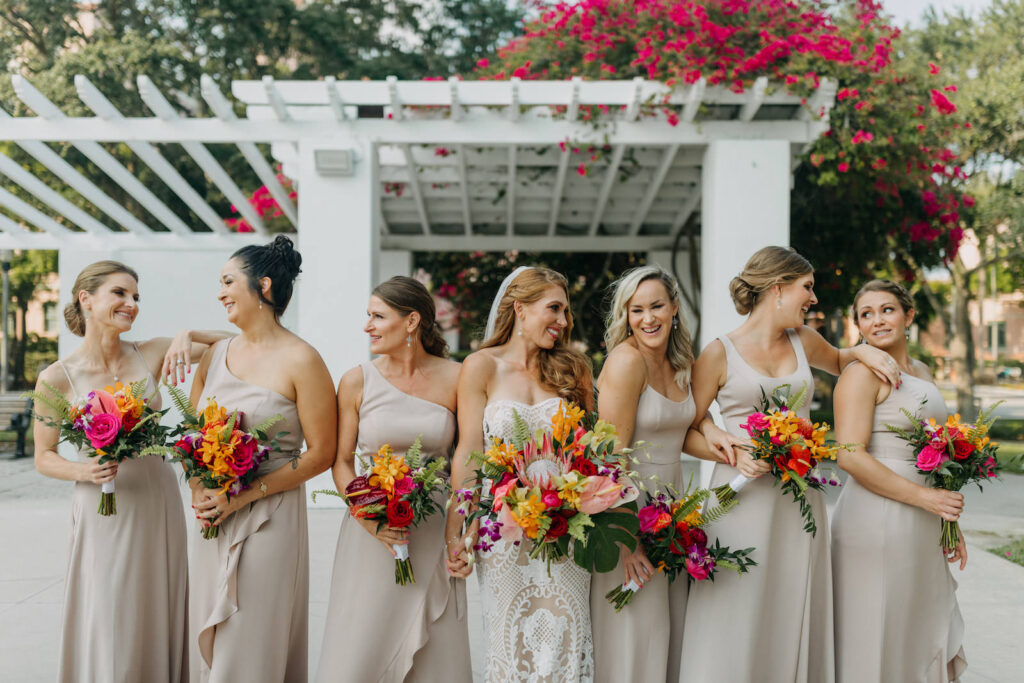 Boho Tropical Bride with Bridesmaids in Mix and Match Taupe Dresses Holding Colorful Floral Bouquets | Tampa Bay Wedding Photographer Amber McWhorter Photography | Wedding Hair and Makeup Femme Akoi Beauty Studio