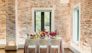 Whimsical and Colorful Wedding Reception Decor, White Dining Chairs, Yellow, Red and White Candlesticks, Colorful Flower Low Centerpieces | St. Pete Modern Industrial Wedding Venue Red Mesa Events | Tampa Wedding Photographer Dewitt for Love | Linen Rentals Kate Ryan Event Rentals