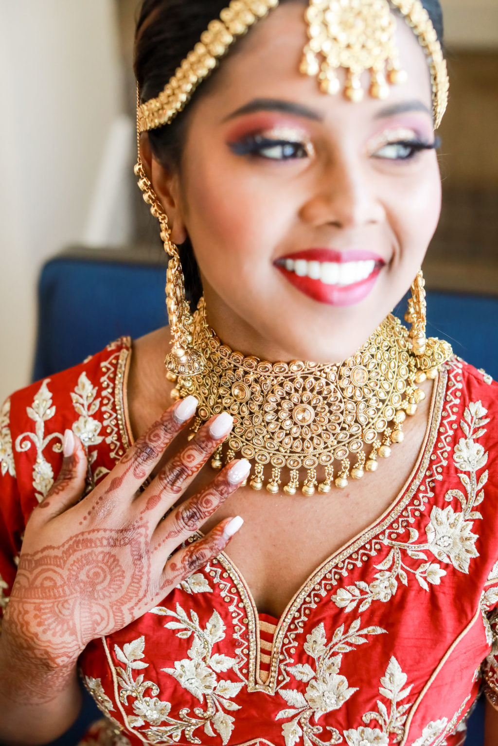 Hindu Indian Bride in Red and Gold Lengha Dress, Henna Tattoo Hands, Elaborate Gold Choker, Headpiece and Dangle Earrings | Tampa Bay Wedding Photographer Lifelong Photography Studios