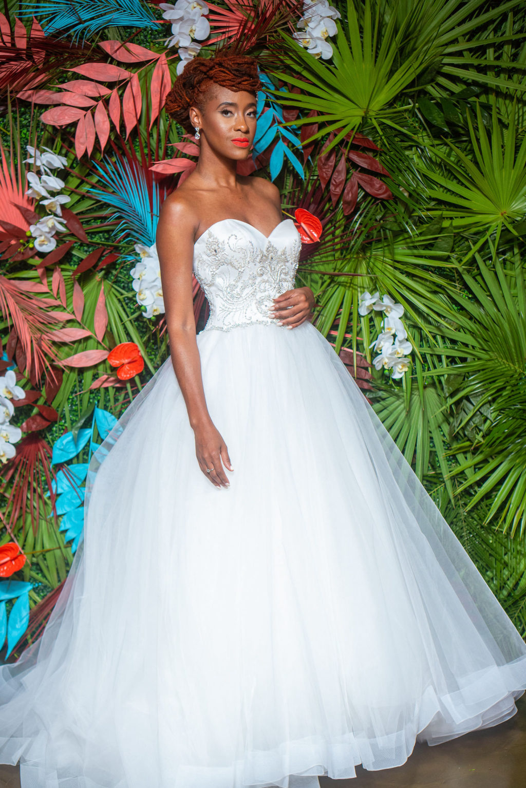Dearly Beloved Fashion Show, Bride Wearing Ballgown Wedding Dress wtih Beaded Corset Detailing and Full Tull Skirt Designed by Royal Bridal, Modern Tropical Floral Wall with Green, Pink and Aqua Blue | Florida Wedding Venue 7th and Grove