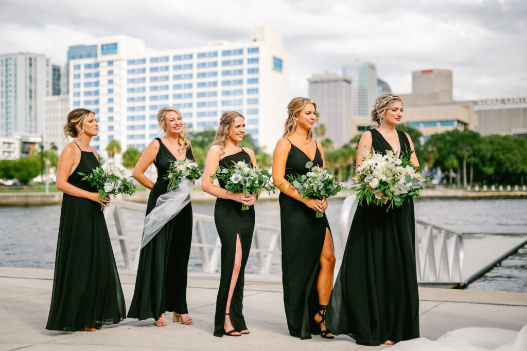 Florida Modern Elegant Bridesmaids in Mix and Match Black Dresses During Waterfront Wedding Ceremony | Wedding Venue Tampa River Center