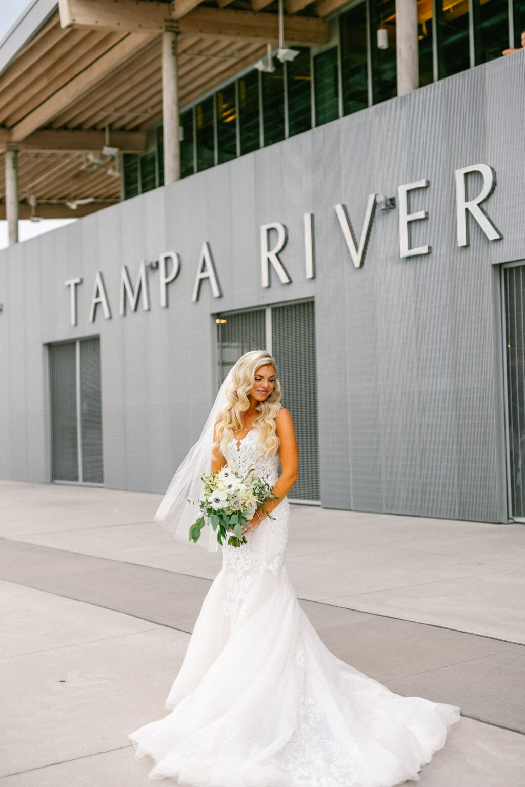 Modern Elegant Florida Bride Wearing Romantic Lace and Tulle Skirt Mermaid Wedding Dress Outside Wedding Venue Tampa River Center