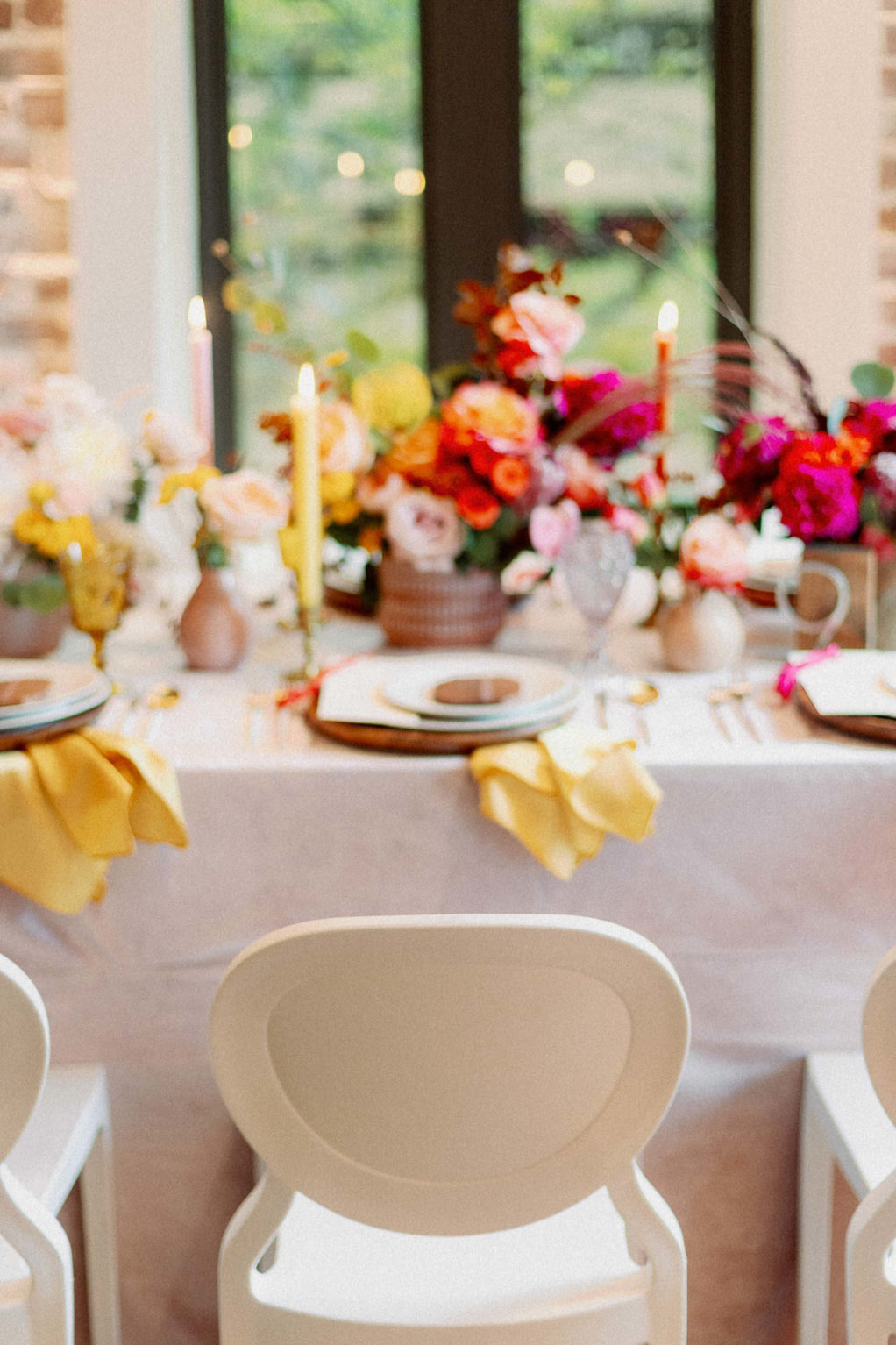 Whimsical and Colorful Wedding Reception Decor, White Dining Chairs, Yellow, Red and White Candlesticks, Colorful Flower Low Centerpieces | St. Pete Modern Industrial Wedding Venue Red Mesa Events | Tampa Wedding Photographer Dewitt for Love | Linen Rentals Kate Ryan Event Rentals