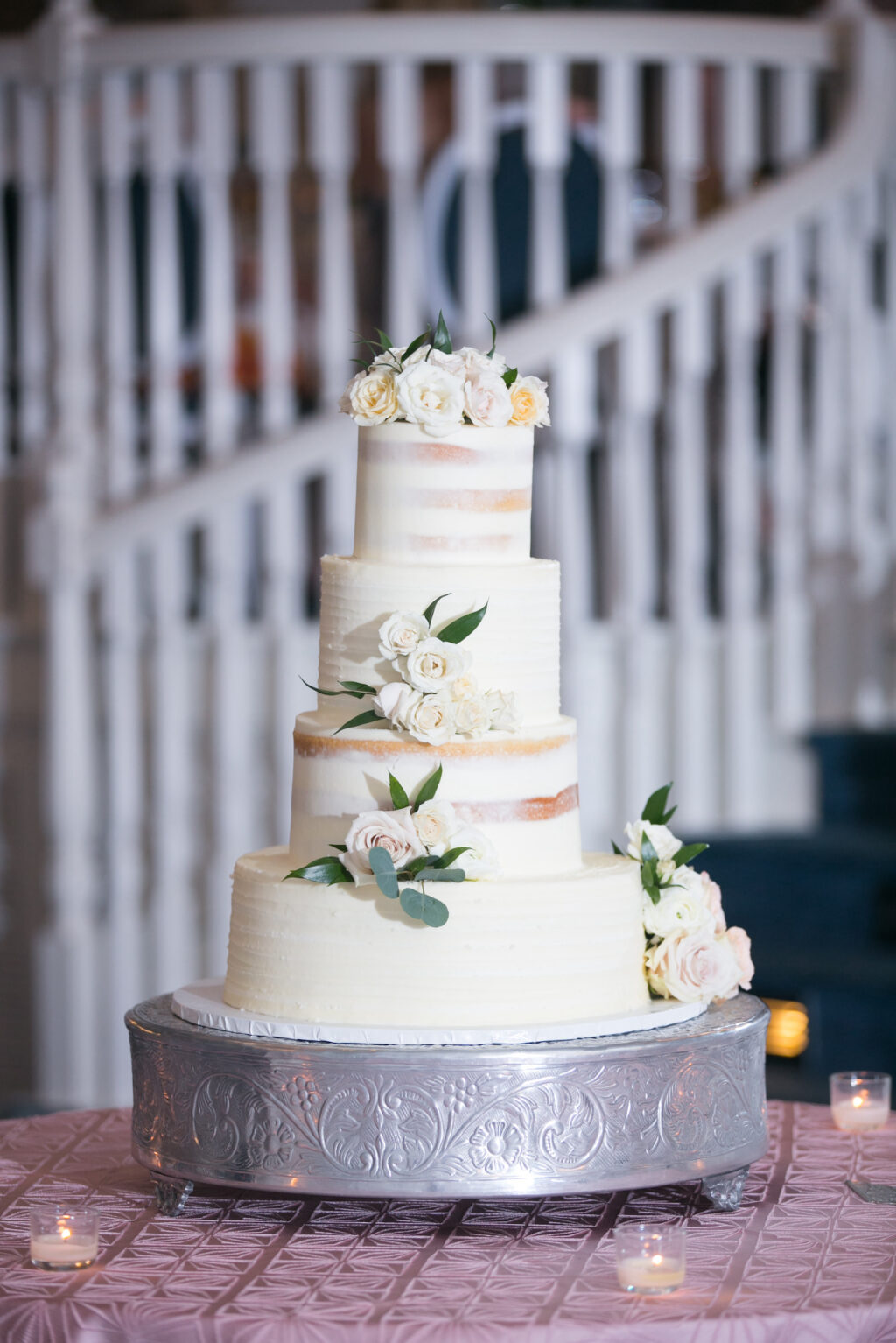 Four Tier Semi Naked Wedding Cake with White Floral and Greenery Garnish