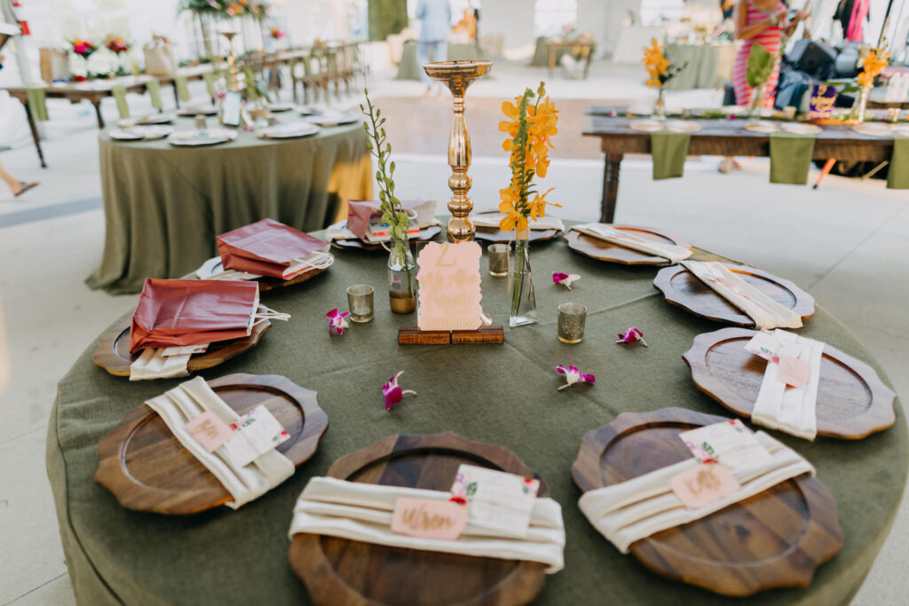 Boho Tropical Wedding Reception Decor, Round Table with Sage Green Table Linen, Wooden Chargers, Single Yellow Flower in Vase, Gold Candlestick | Tampa Bay Wedding Photographer Amber McWhorter Photography | Wedding Rentals Kate Ryan Event Rentals