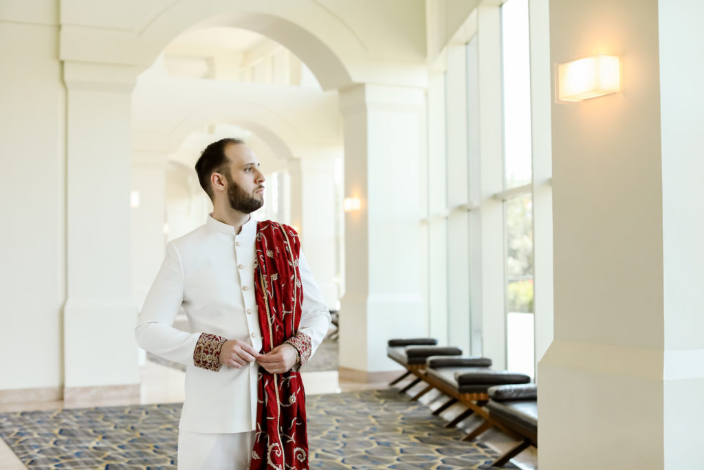Indian Hindu Groom Wearing White Bandhgala with Red and Gold Dupatta Draped Over Shoulder | Tampa Bay Wedding Photographer Lifelong Photography Studios