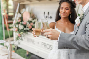 Boho Mid-Century Modern Bride and Groom Cheering Champagne Outside Mobile Bar | Florida Wedding Venue Mision Lago Estates | Big Fake Wedding Tampa