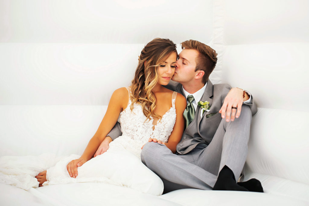Bride and Groom on White Bounce House | Tampa Bay Wedding Photographer Limelight Photography | Wedding Planner MDP Events | Wedding Dress Truly Forever Bridal Sarasota | Wedding Hair and Makeup Adore Bridal