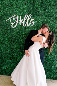 Bride and Groom First Dance Wedding Portrait with Hedge Wall and Custom Last Name Sign