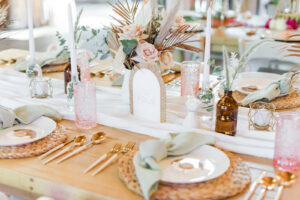 Boho Mid-Century Modern Wedding Reception Decor, Natural Long Wooden Table, Wicker Chargers, Sage Green Linen Napkins, Gold Flatware, Mix and Match Small Vases, White Candlesticks, Dried Leaves, Blush Pink Roses, Pampas Grass | Tampa Bay Wedding Planner Becca's Bloomin' Buds | Big Fake Weddings Tampa