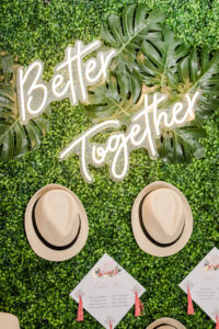 White Neon "Better Together" Sign on Greenery Boxwood Wall and Old Cuban Tan Hats | Tampa Bay Wedding Planner Eventfull Weddings | Wedding Rentals Gabro Event Services