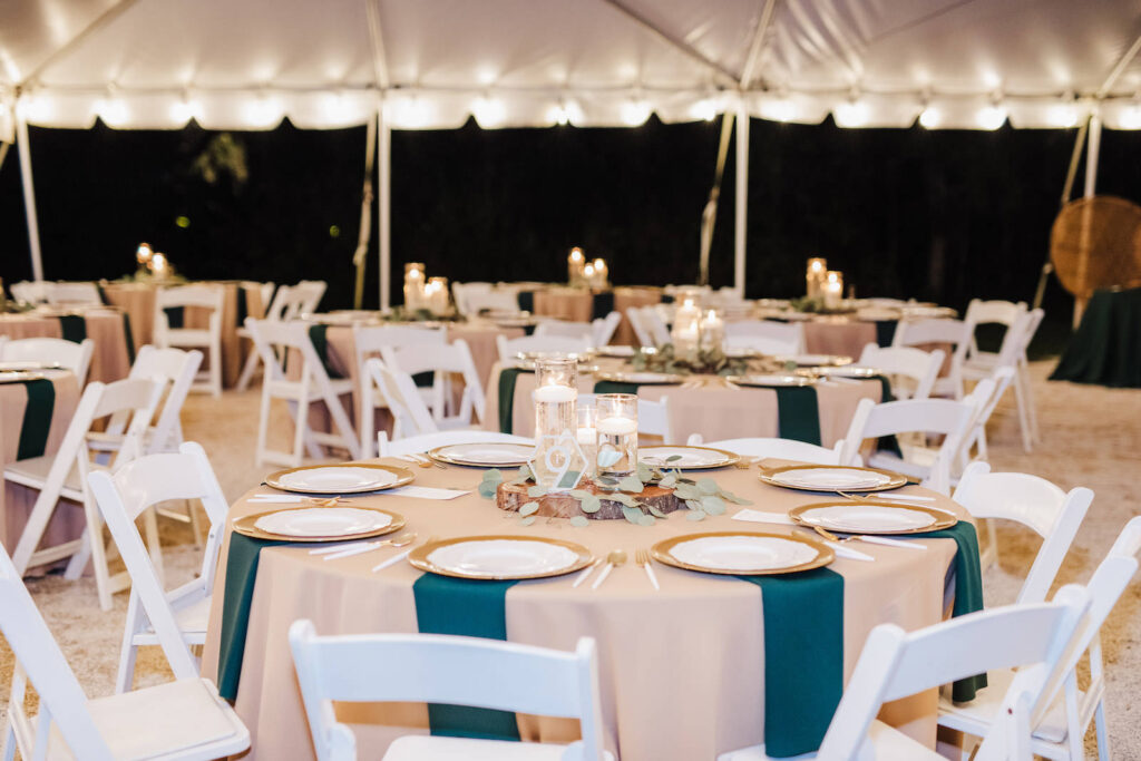 Outdoor Tented Wedding Reception with Tan Linens, Gold Chargers, and Emerald Green Napkins | Florida Wedding Venue Paradise Springs