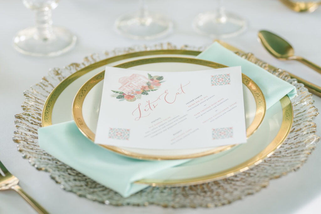 Old Havana Cuban Wedding Tabletop Reception Decor, Gold Rimmed China Plates, Turquoise Linen Napkin, Gold Flatware, White Diamond Shaped Menu with Watercolor Wedding Venue Image of Historic The Cuban Club | Tampa Bay Wedding Planner Eventfull Weddings | Wedding Rentals A Chair Affair