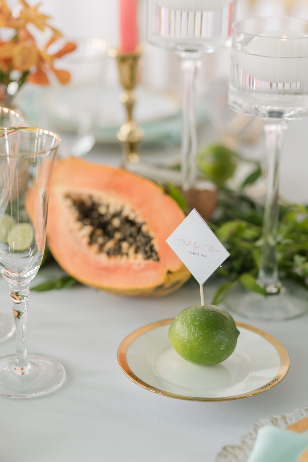 Tropical Wedding Reception Decor, Gold Rimmed Plate with Lime Fruit and Diamond Shaped Place Card, Papaya Fruit Centerpiece | Tampa Bay Wedding Planner Eventfull Weddings | Tabletop Wedding Rentals A Chair Affair