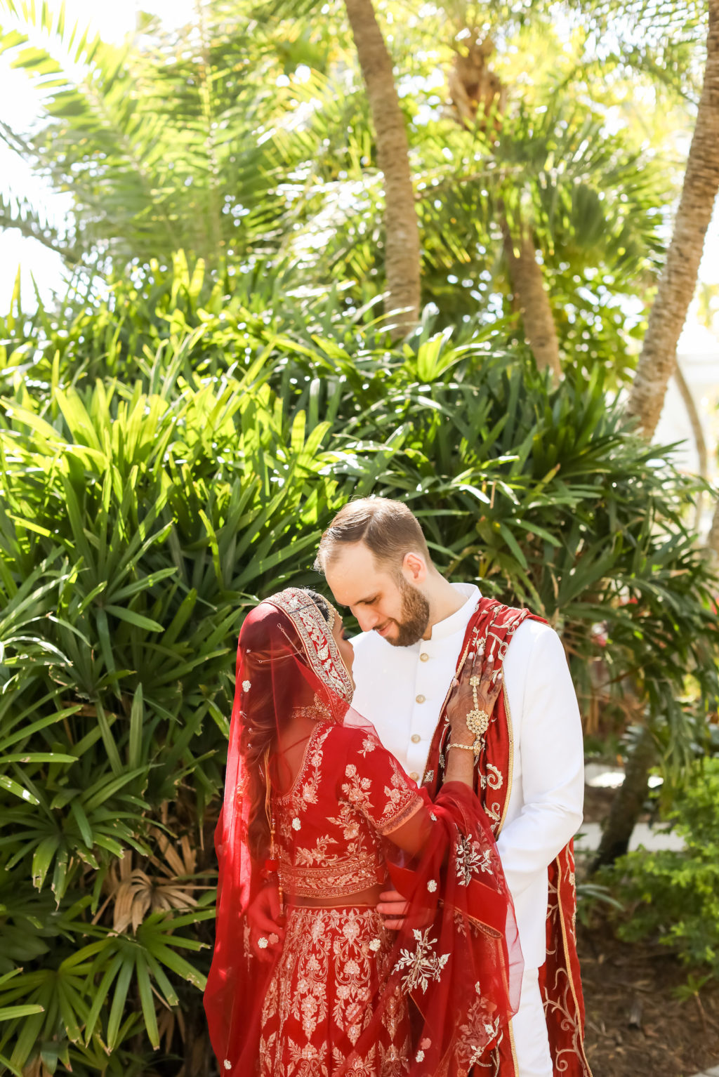 Indian Hindu Bride Wearing Red and Gold Lengha Two Piece Dress and Veil, Groom Wearing White Bandhgala Suit with Red and Gold Dupatta | Tampa Bay Wedding Photographer Lifelong Photography Studios