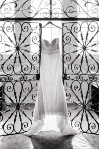 Vintage Strapless Wedding Dress Hanging on Elaborate Iron Gate Doors
