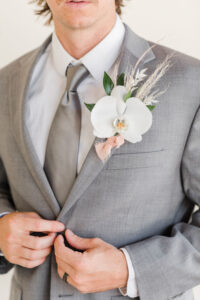 Groom Wearing Gray Wedding Suit and Silver Tie with White Calla Lily and Pampas Grass Boutonniere | Big Fake Wedding Tampa