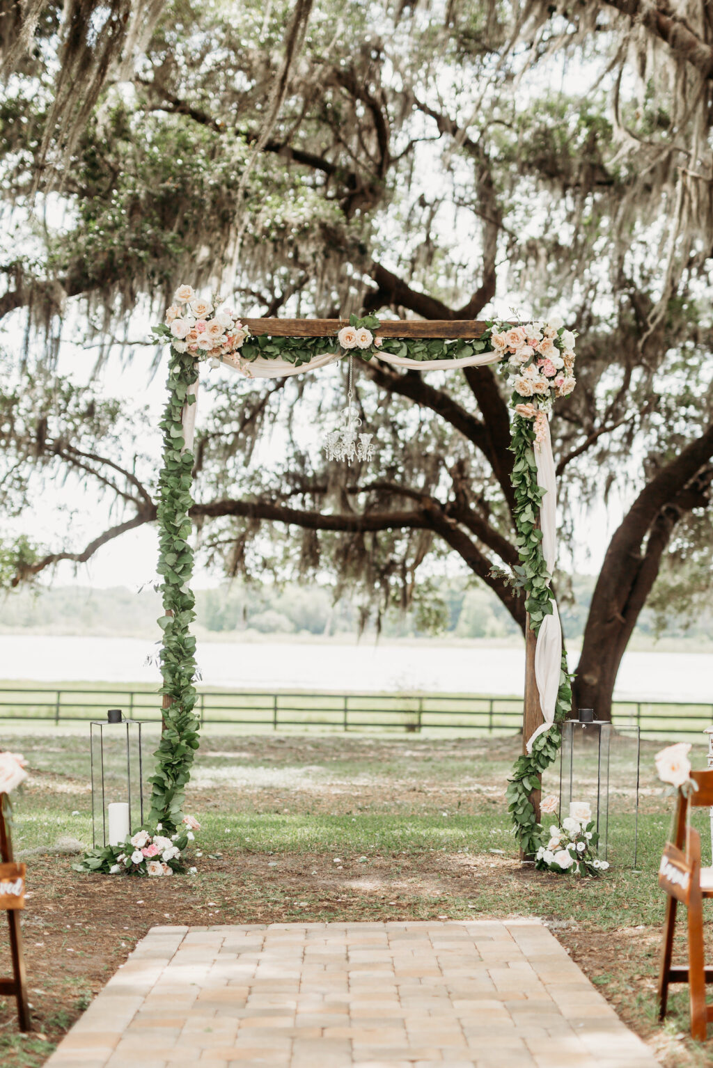Wooden Wedding Ceremony Arch with Greenery Detail, Florals, and Drapery for Rustic Ceremony | Covington Farms Florida Wedding Venue