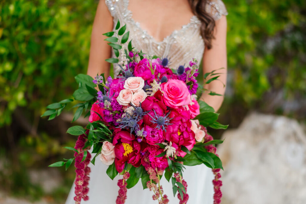 Bride Holding Jewel Tone Floral Bouquet, Pink and Fuschia Roses and Peonies, Purple Flowers, Thistle, Greenery Leaves, Hanging Amaranthus | Tampa Bay Wedding Florist Iza's Flowers