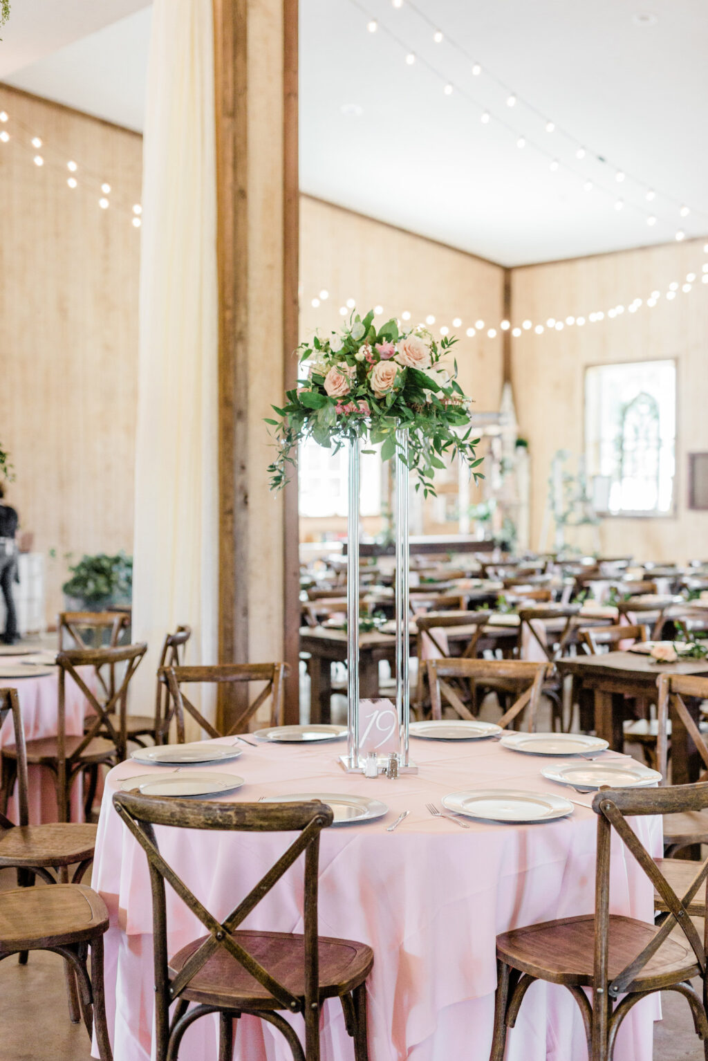 Rustic Wooden Chairs and Pale Pink Linens with Tall Floral Centerpieces on Wedding Reception Tablescapes | Tampa Wedding Venue Covington Farms