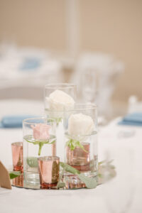 Clear Vase with White Rose and Pink Roses in Water Next to Rose Gold Candle Wedding Décor | Elegant Affairs by Design