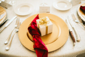 Fall wedding reception decor, gold charger, red silk napkin, white favor box | Tampa wedding photographer Bonnie Newman Creative | Wedding planner Coastal Coordinating