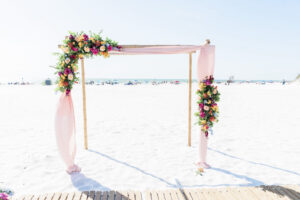 Wedding Arch with Pink Draping and Bright Floral Detail with Greenery | South Florida Hilton Clearwater Beach Wedding
