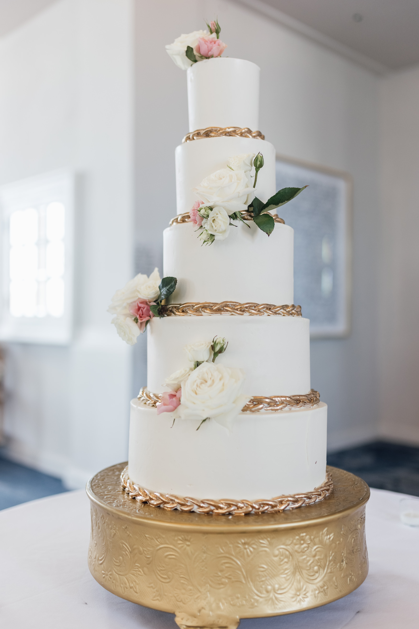 Five Tier White Wedding Cake with Rose Floral Detail, Gold Trim, and Greenery