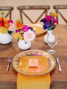 Whimsical Art Inspired Wedding Reception Decor, Low Fuschia Pink and Blush Roses, Orange, Purple and Yellow Flower Centerpieces, Gold and Clear Glass Charger, Yellow Linen Napkin | Tampa Bay Wedding Photographer Dewitt for Love | Wedding Planner Wilder Mind Events | Wedding Rentals Gabro Event Services | Wedding Linens Over the Top Rental Linens