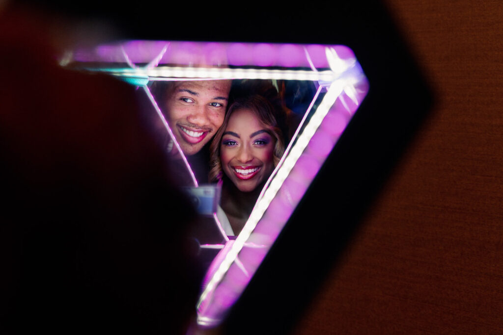 Fun Bride and Groom Wedding Photo Behind Purple Triangular Neon Light | Tampa Bay Wedding Photographer Dewitt for Love | Wedding Planner Wilder Mind Events