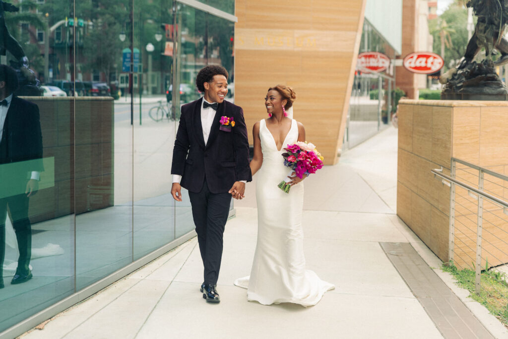 Modern Bride Wearing Classic Plunging V Neckline Wedding Dress Holding Colorful Vibrant Fuschia Pink, Blush and Yellow Floral Bridal Bouquet, Groom Wearing Black Tuxedo and Colorful Floral Boutonniere | Tampa Bay Wedding Photographer Dewitt for Love