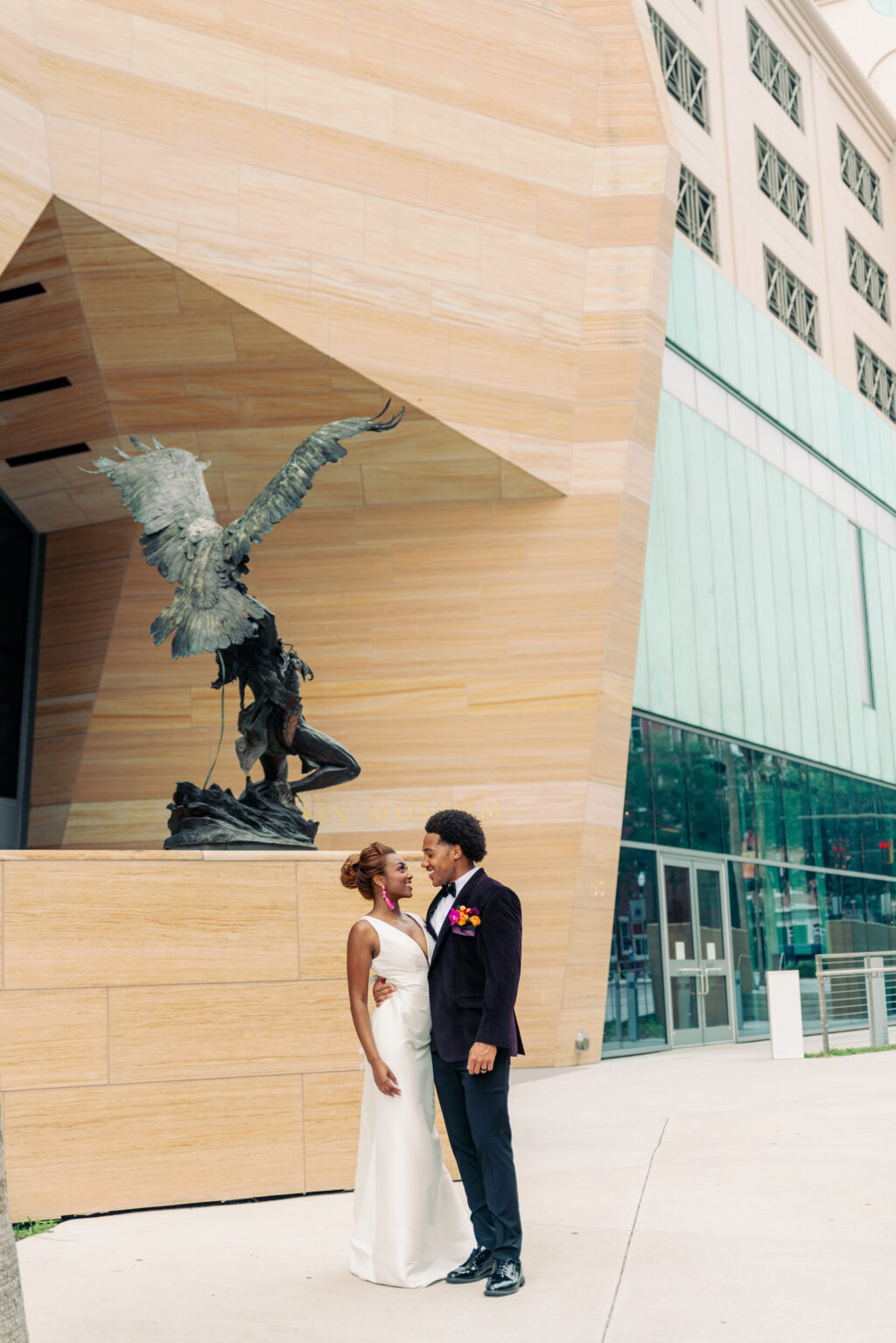 Modern Bride Wearing Classic Plunging V Neckline Wedding Dress Holding Groom Wearing Black Tuxedo and Colorful Floral Boutonniere | Tampa Bay Wedding Photographer Dewitt for Love