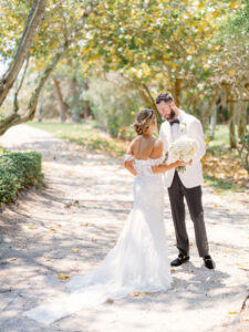 Florida Bride and Groom First Look at Resort at Longboat Key Club, Wearing Provinias Wedding Dress with Floral Applique Off the Shoulder Sleeves with Sweetheart Neckline, Braided Updo, Luxurious Round Ivory Floral Bouquet