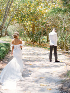 Florida Bride and Groom First Look at Resort at Longboat Key Club, Wearing Provinias Wedding Dress with Floral Applique Off the Shoulder Sleeves with Sweetheart Neckline, Braided Updo, Luxurious Round Ivory Floral Bouquet