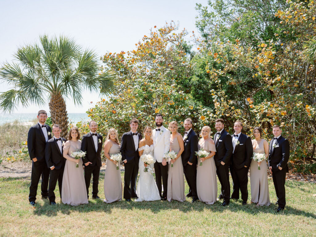 Elegant Florida Wedding Party, Groomsmen Wearing Classic Black Tuxedos, Bridesmaids in Long Mismatched Beige Birdie Grey Dresses | Sarasota Wedding Venue The Resort at Longboat Key Club | South Harbourside Lawn