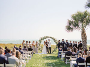 Waterfront Wedding Ceremony, Bride and Groom Exchange Vows at Modern Circle Floral Arch with Classic White and Greenery Florals | Sarasota Wedding Venue The Resort at Longboat Key Club | South Beach Lawn