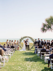 Waterfront Wedding Ceremony, Bride and Groom Exchange Vows at Modern Circle Floral Arch with Classic White and Greenery Florals | Sarasota Wedding Venue The Resort at Longboat Key Club | South Beach Lawn