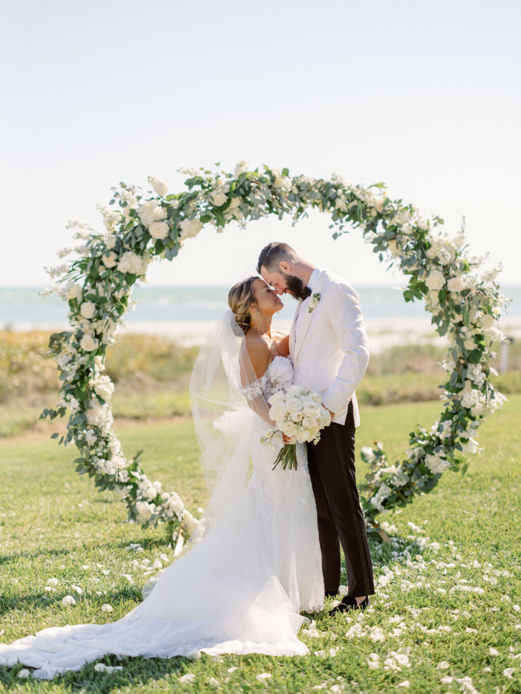 Waterfront Wedding Ceremony, Bride and Groom at Modern Circle Floral Arch with Classic White and Greenery Florals | Sarasota Wedding Venue The Resort at Longboat Key Club | South Beach Lawn