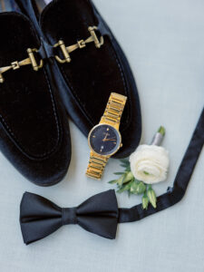 Luxurious Florida Wedding Groom Attire and Details, Black Velvet Loafers with Gold Metal Hardware, Citizen Watch with Matte Face, Ivory Rose Boutonniere, Classic Black Bow Tie