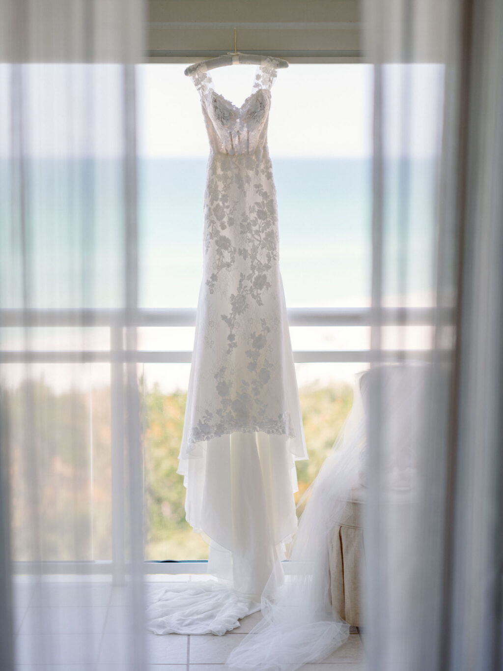 Luxurious Provinias Wedding Dress with Floral Appliqué Sleeves and Fitted Corset, Hanging From Balcony Overlooking Gulf of Mexico | Florida Wedding Venue The Resort at Longboat Key Club