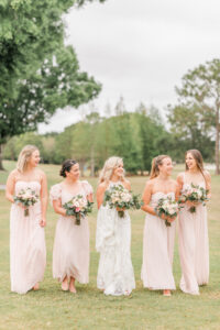 Romantic Pink St. Pete Garden Wedding | Bride Wearing Halter Lace Applique and Illusion Wedding Dress, Bridesmaids in Blush Pink Mix and Match Dresses Holding Floral Bouquets | Tampa Bay Wedding Florist Brides N Blooms Designs