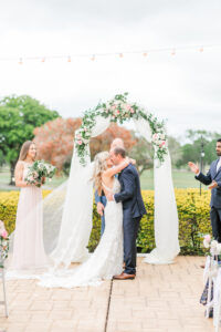 Romantic Pink St. Pete Outdoor Garden Wedding Ceremony | Bride and Groom Exchanging First Kiss Wedding Ceremony Veil Photo