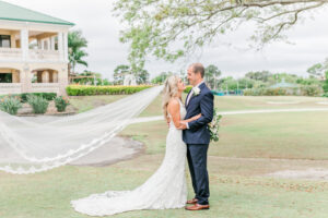 Romantic Pink Outdoor Garden St. Pete Wedding | Bride Wearing Full Length Veil with Groom | Wedding Venue Feather Sound Country Club