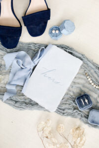 Romantic Coastal Chic Blue Wedding Accessories, Hers Wedding Vows Book, Pearl Earrings in Dusty Blue Velvet Ring Box, Navy Blue Velvet Sandal Wedding Heel Shoes, Diamond Engagement Ring and Wedding Band in Velvet Ring Box, Gray Cheese Cloth Linen | Tampa Bay Wedding Photographer Lifelong Photography Studio