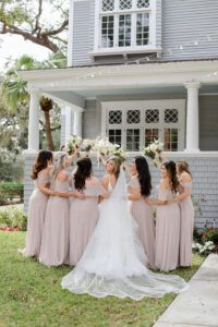 Romantic Blue Coastal Chic Wedding and Bridal Party, Bride Wearing Tulle Ballgown Wedding Dress and Full Length Veil, Bridesmaids in Taupe Dresses with White Floral Bouquets | Tampa Bay Wedding Photographer Lifelong Photography Studio
