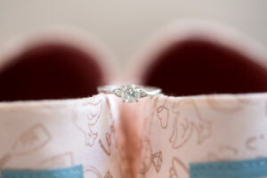 Round Stand-Alone Diamond Engagement Ring with Silver Band On Top of Toms Wedding Shoes | Carrie Wildes Photography